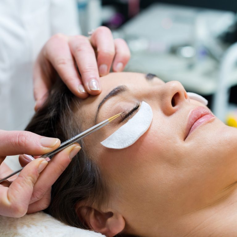 woman having eye lashes tinted in beauty salon